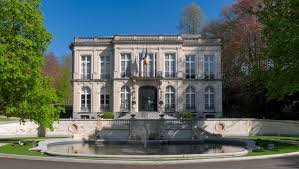 Vue de rue pittoresque d'Auderghem avec un camion de débouchage professionnel garé près d'un bâtiment historique.