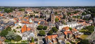 Plombier Braine-l'Alleud devant l'Hôtel de Ville, bâtiment historique avec façade en briques rouges, ambiance rustique.