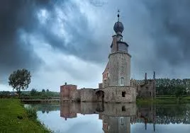 Rue animée de Colfontaine avec camion de débouchage de canalisation stationné près de bâtiments typiques en briques rouges