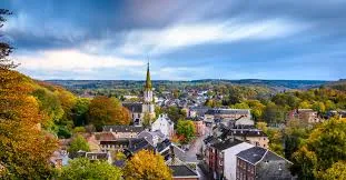 Plombier Eupen devant un bâtiment culturel typique avec façades en briques rouges dans le centre de Eupen.
