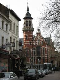 Rue pittoresque de Jette avec équipe de débouchage de canalisation en action, bâtiments typiques en arrière-plan