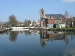 Camionnette de débouchage de canalisation sur une rue typique de La Louvière avec bâtiments anciens en arrière-plan
