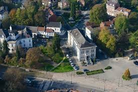 Plombier Watermael Boitsfort rue animée avec maisons bruxelloises et végétation typique du quartier résidentiel chaleureux